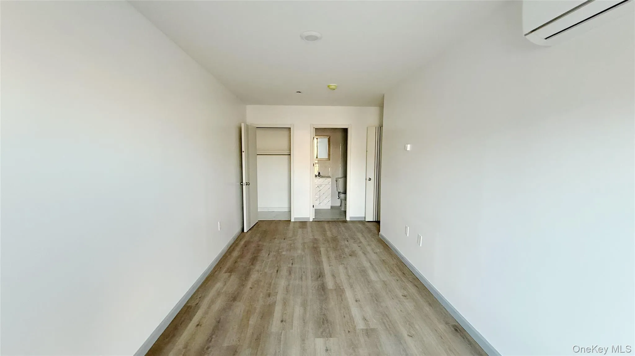 Corridor with a wall mounted air conditioner and light wood-type flooring Corridor with a wall mounted air conditioner and light wood-type flooring