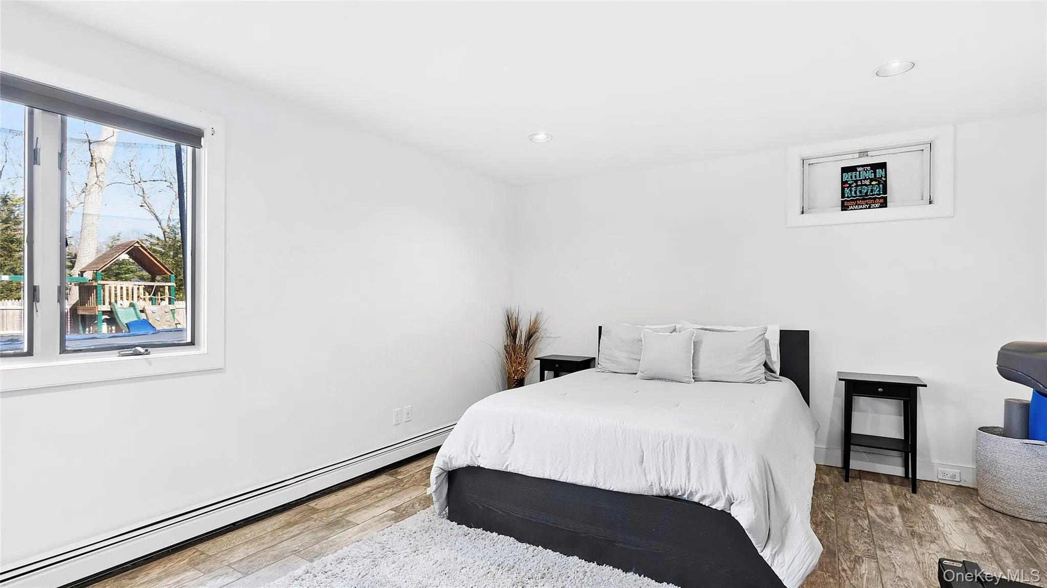 Bedroom featuring a baseboard radiator, light wood finished floors, and recessed lighting Bedroom featuring a baseboard radiator, light wood finished floors, and recessed lighting