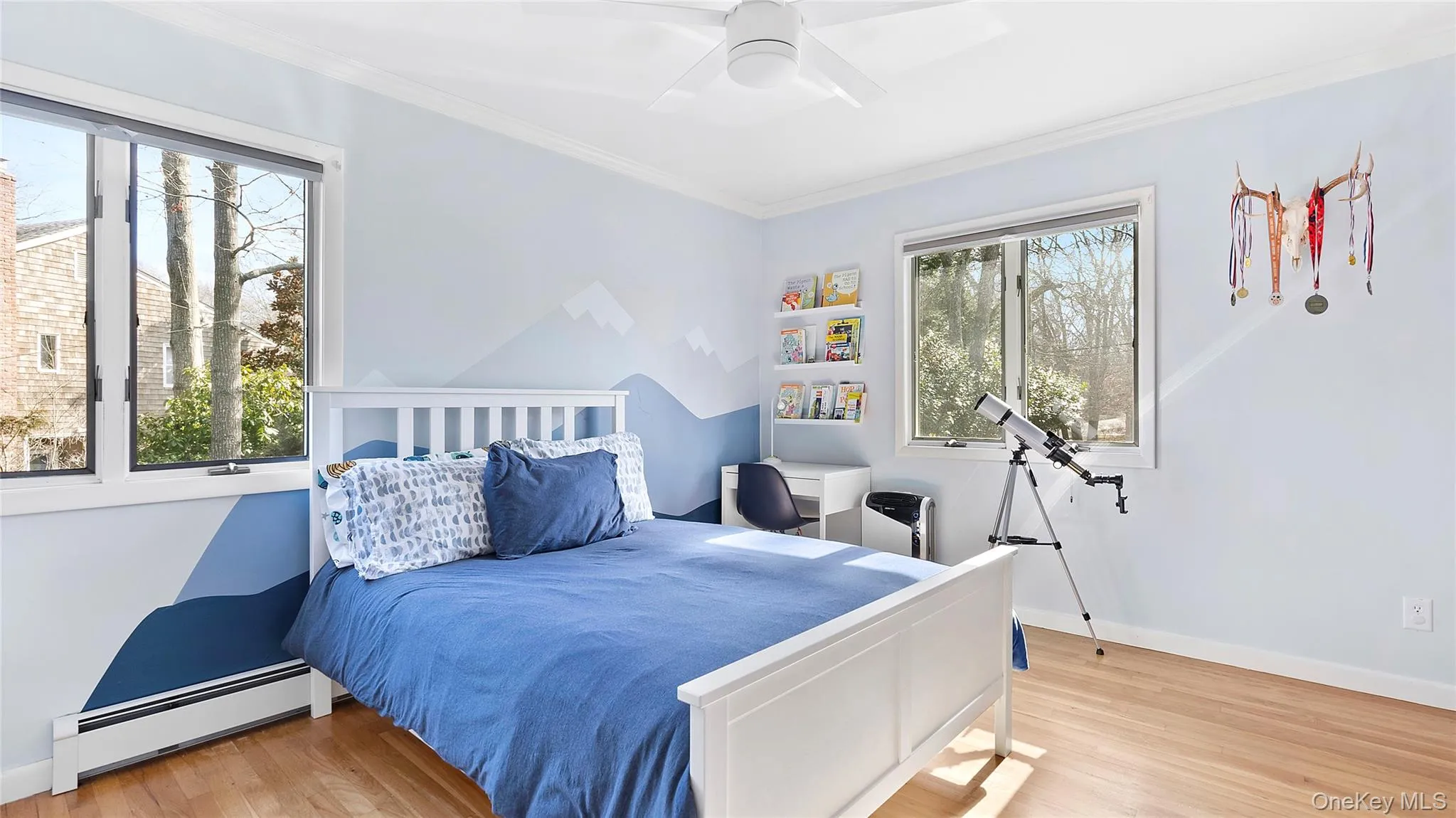 Bedroom with baseboard heating, light wood-style flooring, ceiling fan, and ornamental molding Bedroom with baseboard heating, light wood-style flooring, ceiling fan, and ornamental molding