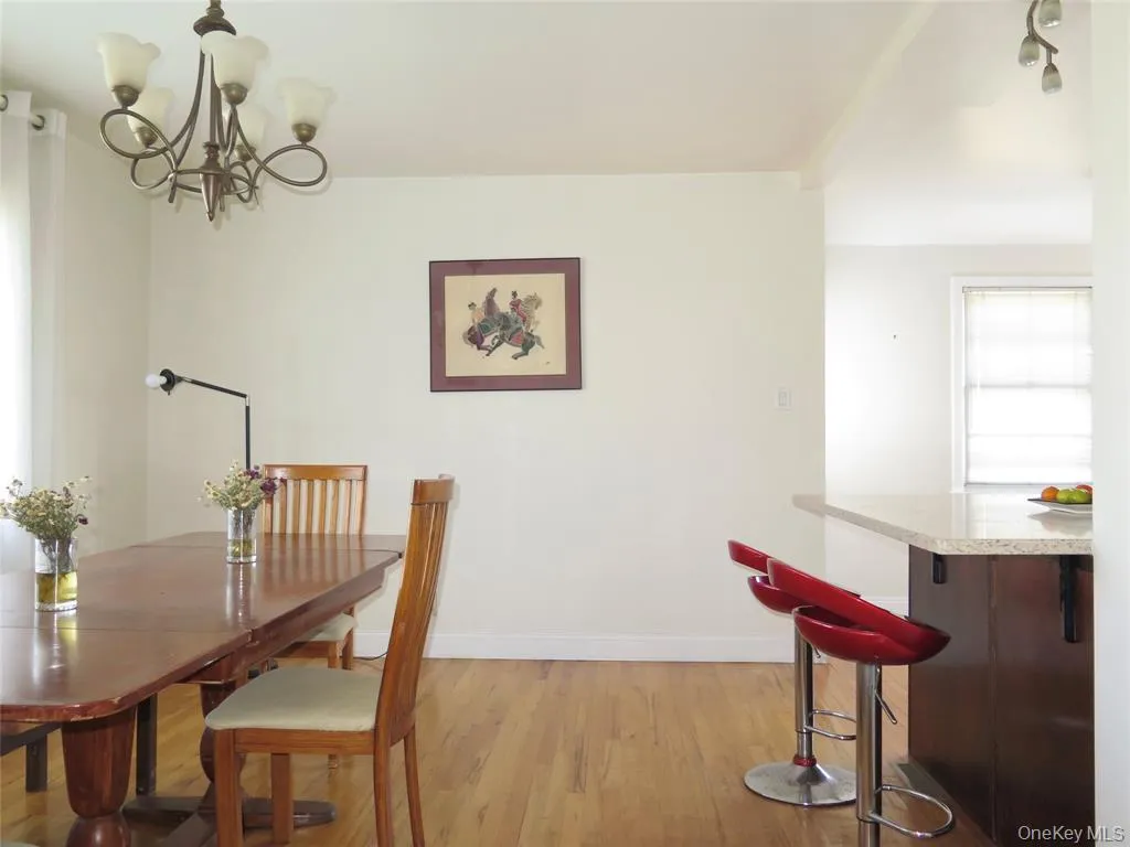 Dining room featuring light wood-style flooring and a chandelier Dining room featuring light wood-style flooring and a chandelier