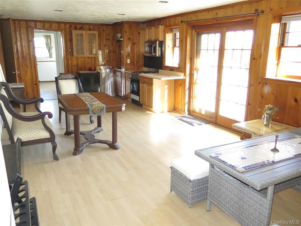 Den with light wood-style floors and wood walls Den with light wood-style floors and wood walls