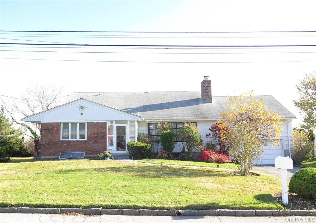 View of front of property with a front yard, a chimney, brick siding, and an attached garage View of front of property with a front yard, a chimney, brick siding, and an attached garage