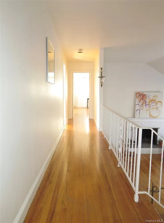 Hallway with baseboards and light wood finished floors Hallway with baseboards and light wood finished floors
