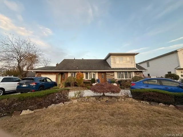 View of front of property featuring an attached garage and a front yard View of front of property featuring an attached garage and a front yard