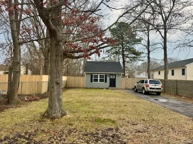 View of front of home with a fenced backyard, an outbuilding, and driveway View of front of home with a fenced backyard, an outbuilding, and driveway