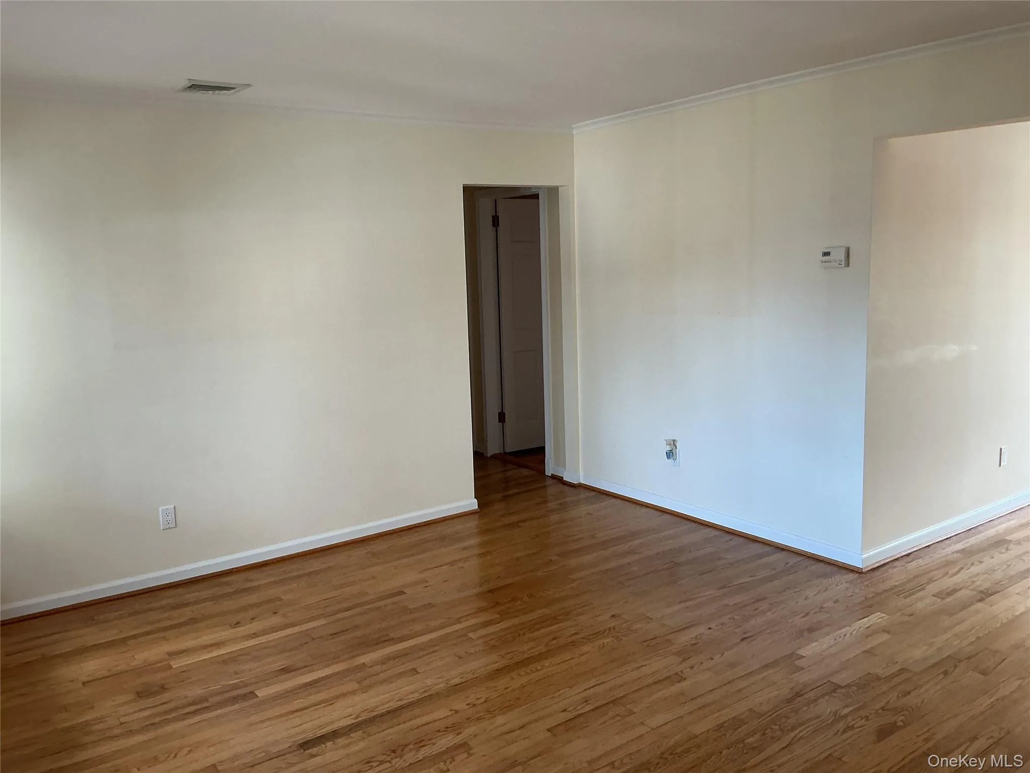 Spare room featuring wood finished floors and baseboards Spare room featuring wood finished floors and baseboards