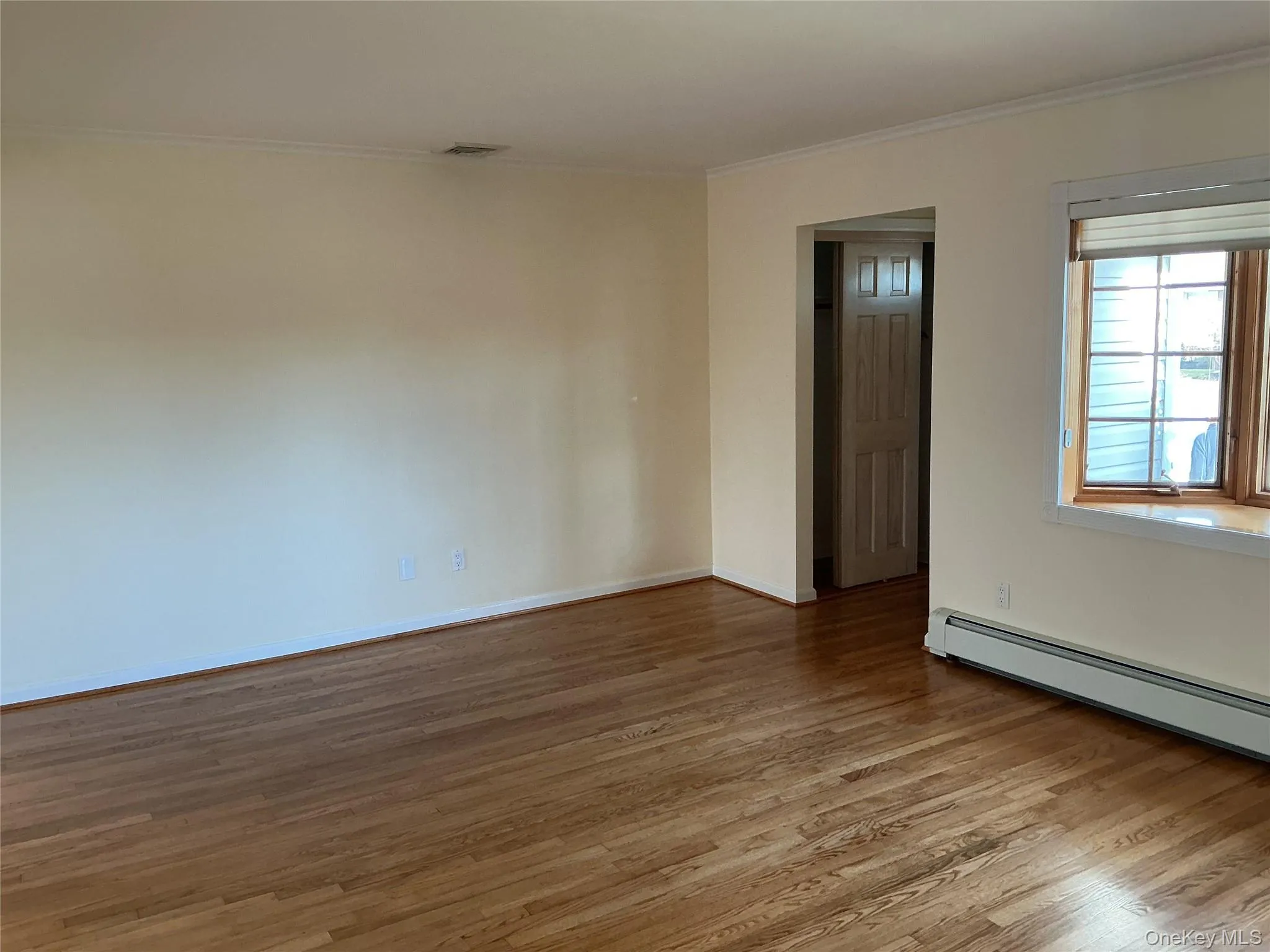 Spare room with wood finished floors and ornamental molding Spare room with wood finished floors and ornamental molding