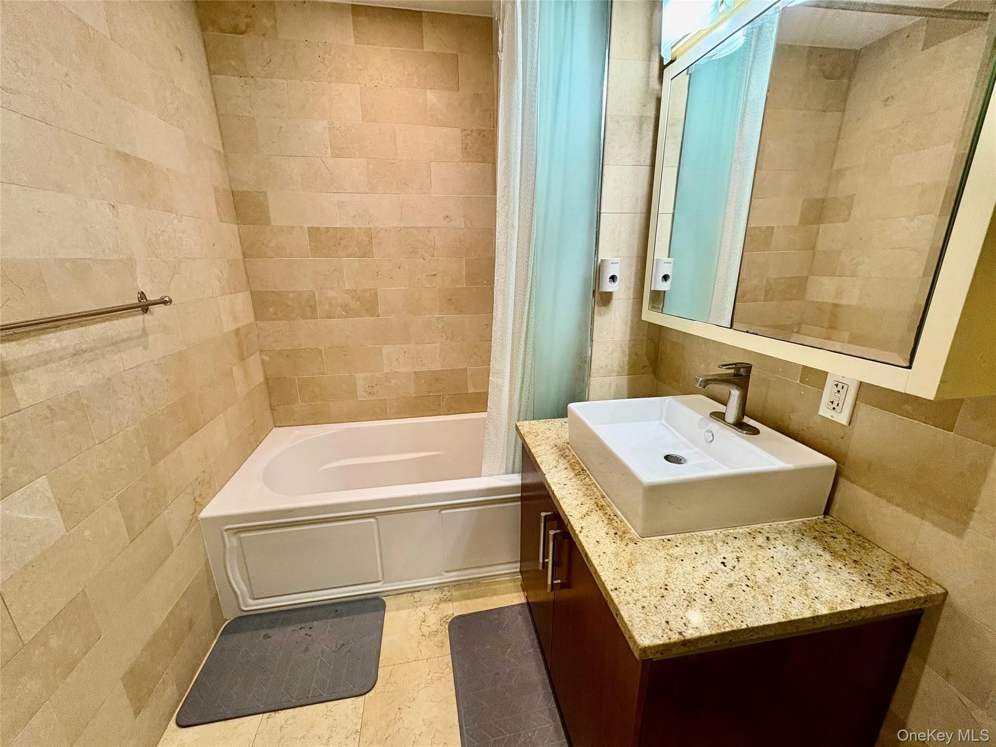 Bathroom with tile walls, vanity, and shower / bath combination with curtain Bathroom with tile walls, vanity, and shower / bath combination with curtain