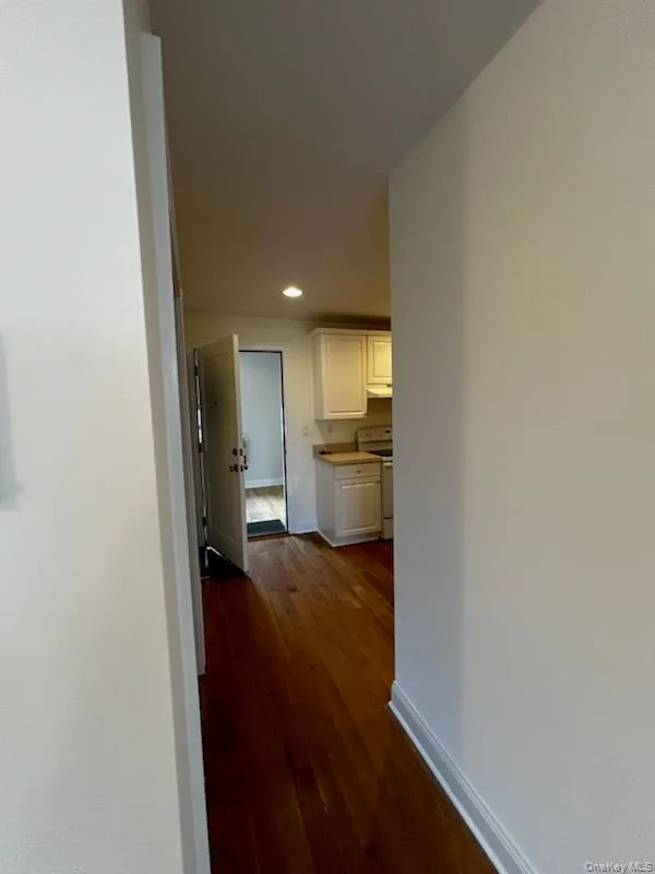 Hall featuring dark wood-type flooring and recessed lighting Hall featuring dark wood-type flooring and recessed lighting