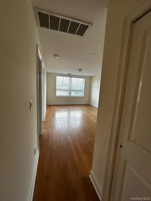 Hallway featuring dark wood finished floors and baseboards Hallway featuring dark wood finished floors and baseboards