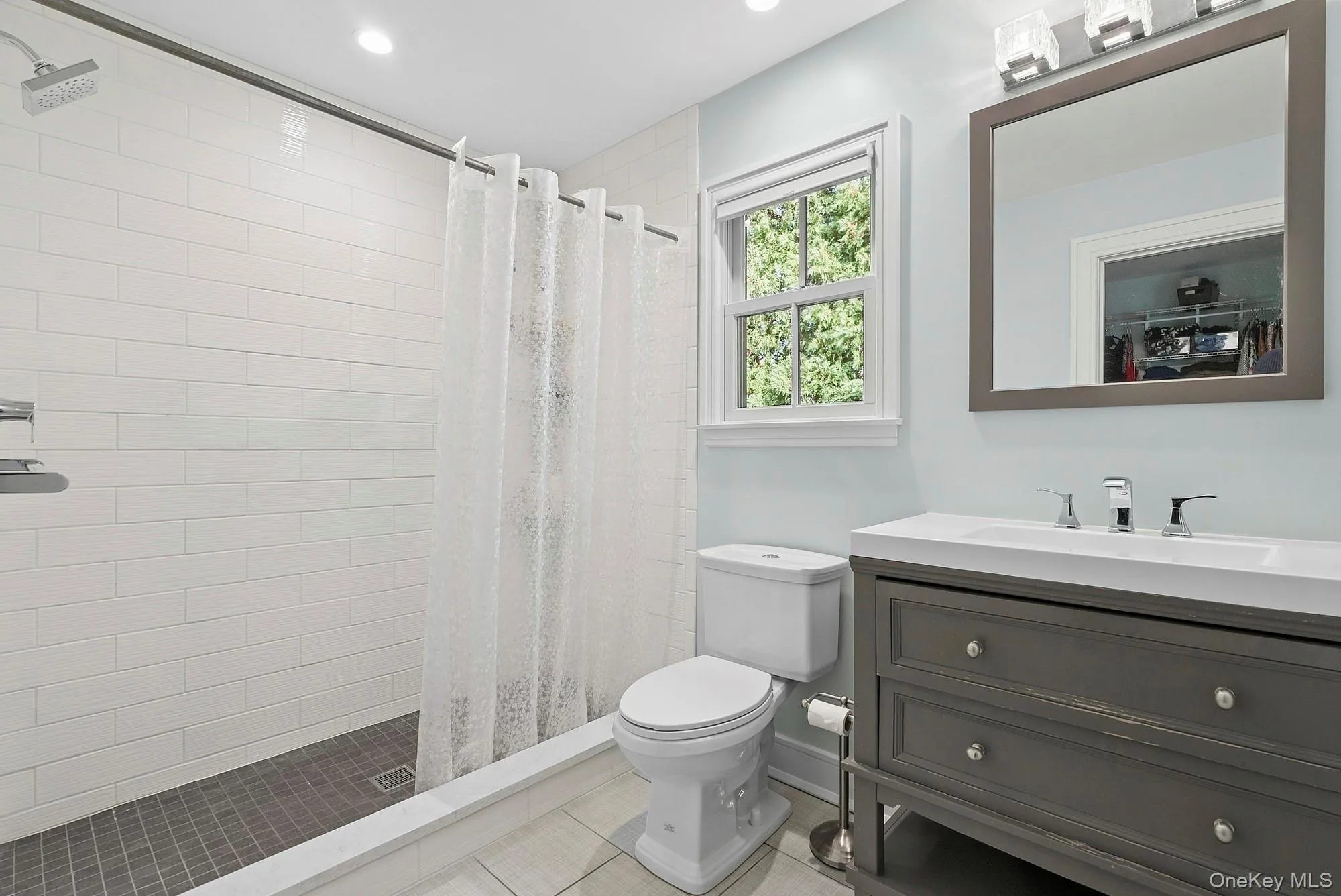 Bathroom featuring a shower stall, vanity, and light tile patterned floors Bathroom featuring a shower stall, vanity, and light tile patterned floors