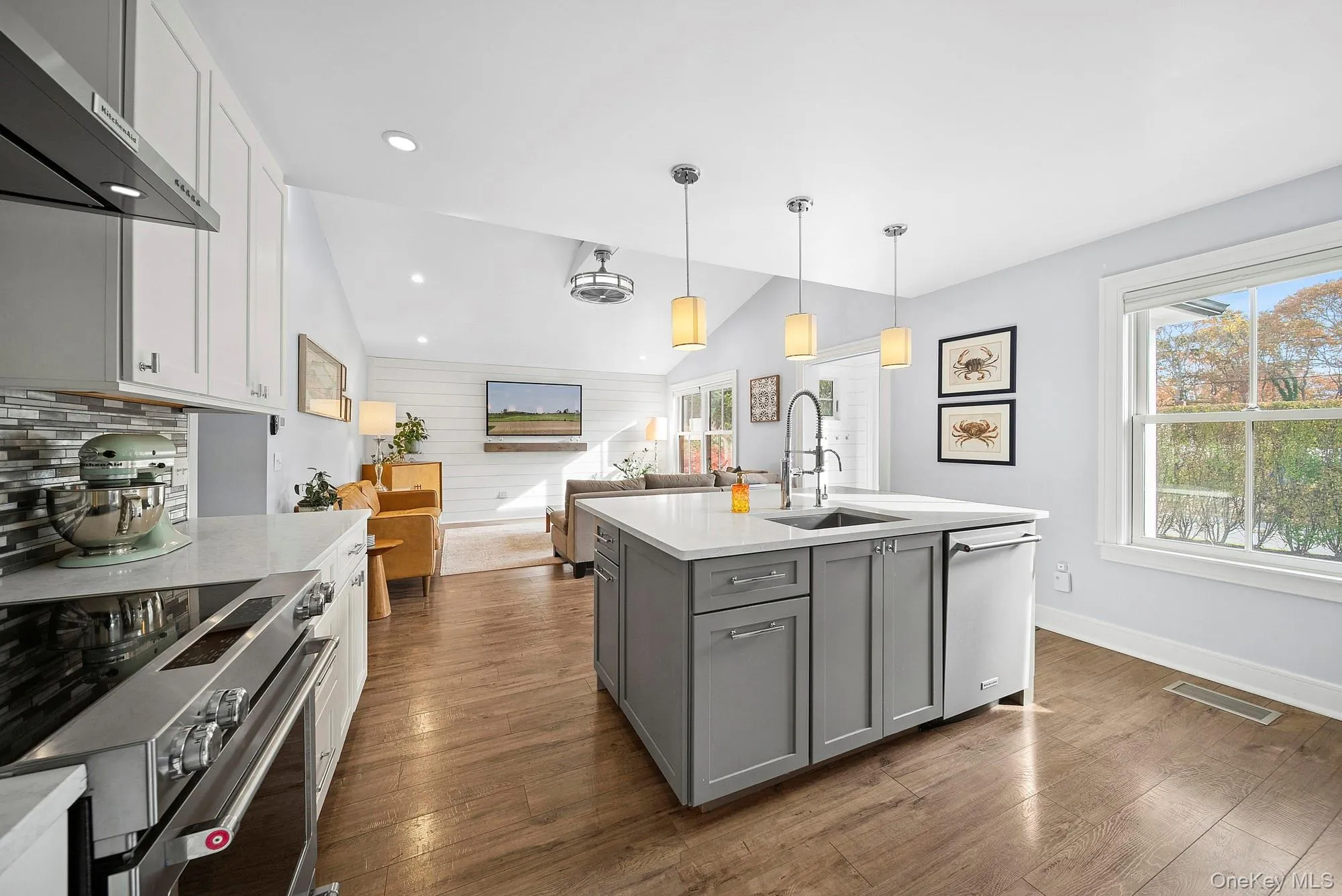 Kitchen with vaulted ceiling, gray cabinets, appliances with stainless steel finishes, open floor plan, and white cabinetry Kitchen with vaulted ceiling, gray cabinets, appliances with stainless steel finishes, open floor plan, and white cabinetry
