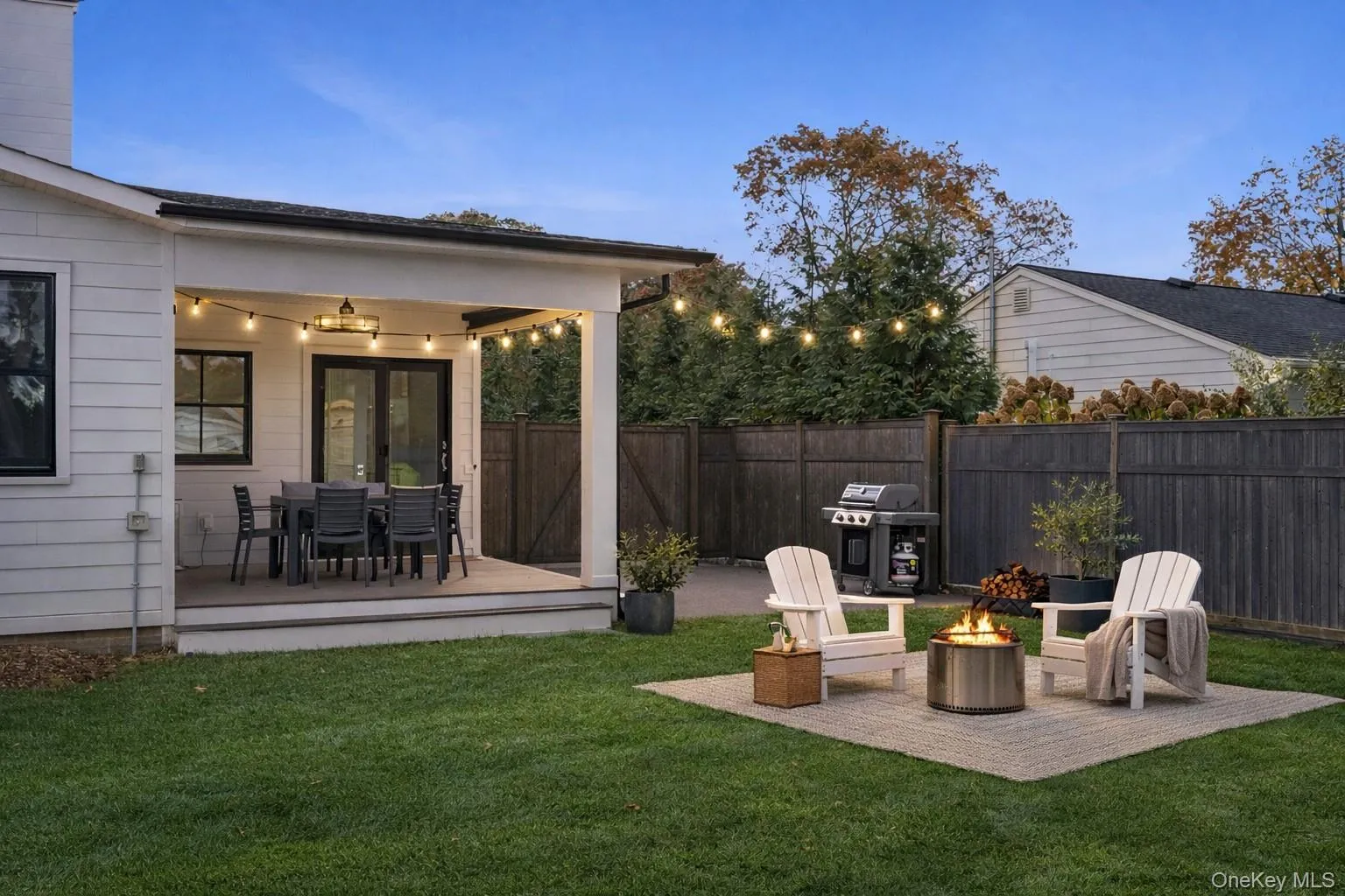 View of yard featuring a wooden deck, a fire pit, and a patio View of yard featuring a wooden deck, a fire pit, and a patio