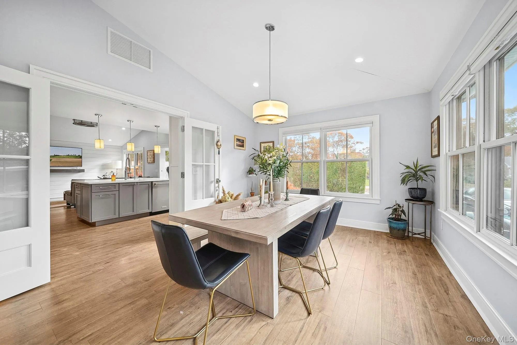 Dining space featuring lofted ceiling, light wood-type flooring, and recessed lighting Dining space featuring lofted ceiling, light wood-type flooring, and recessed lighting