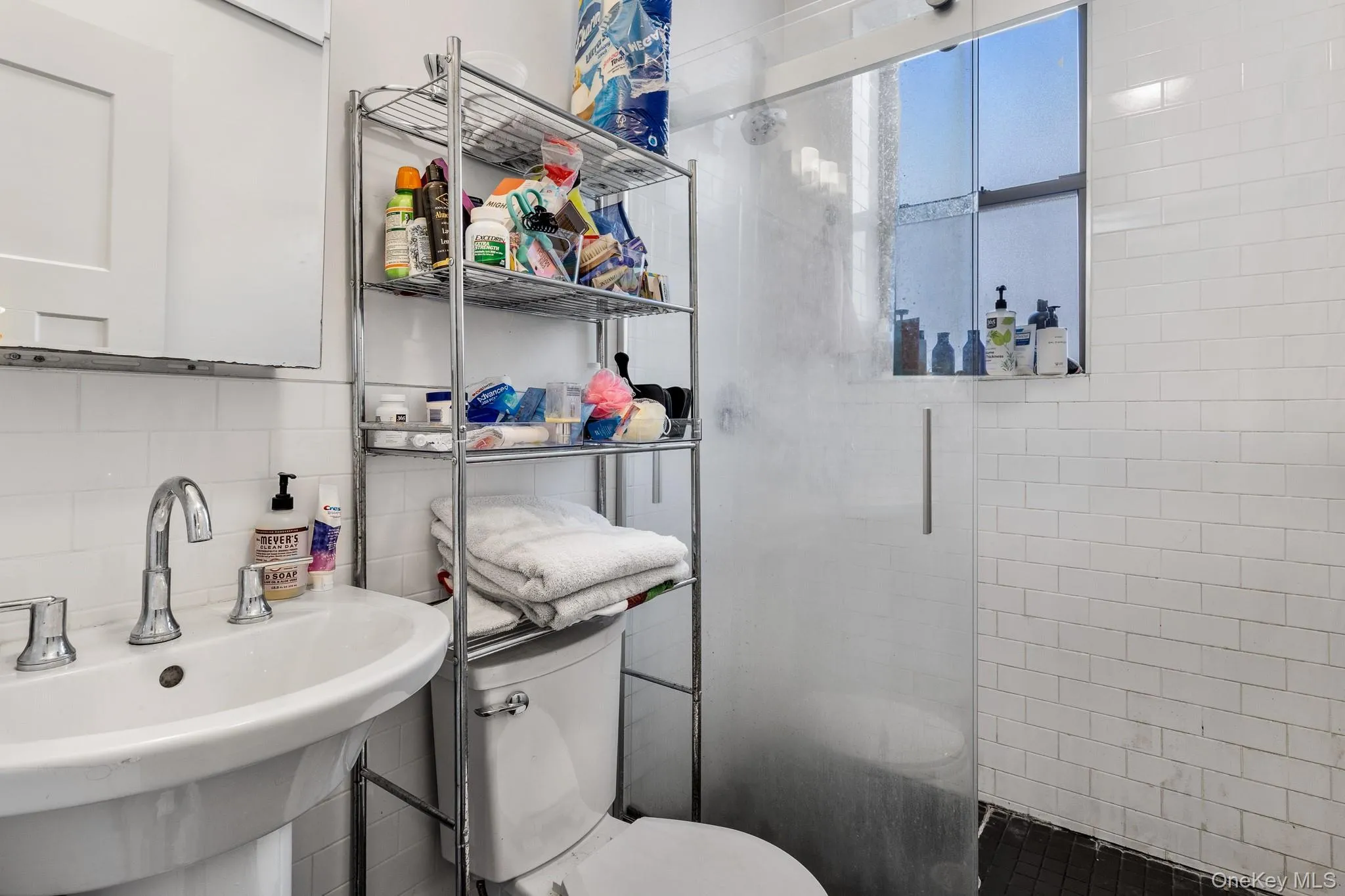 Bathroom featuring a shower stall, tasteful backsplash, and tile walls Bathroom featuring a shower stall, tasteful backsplash, and tile walls