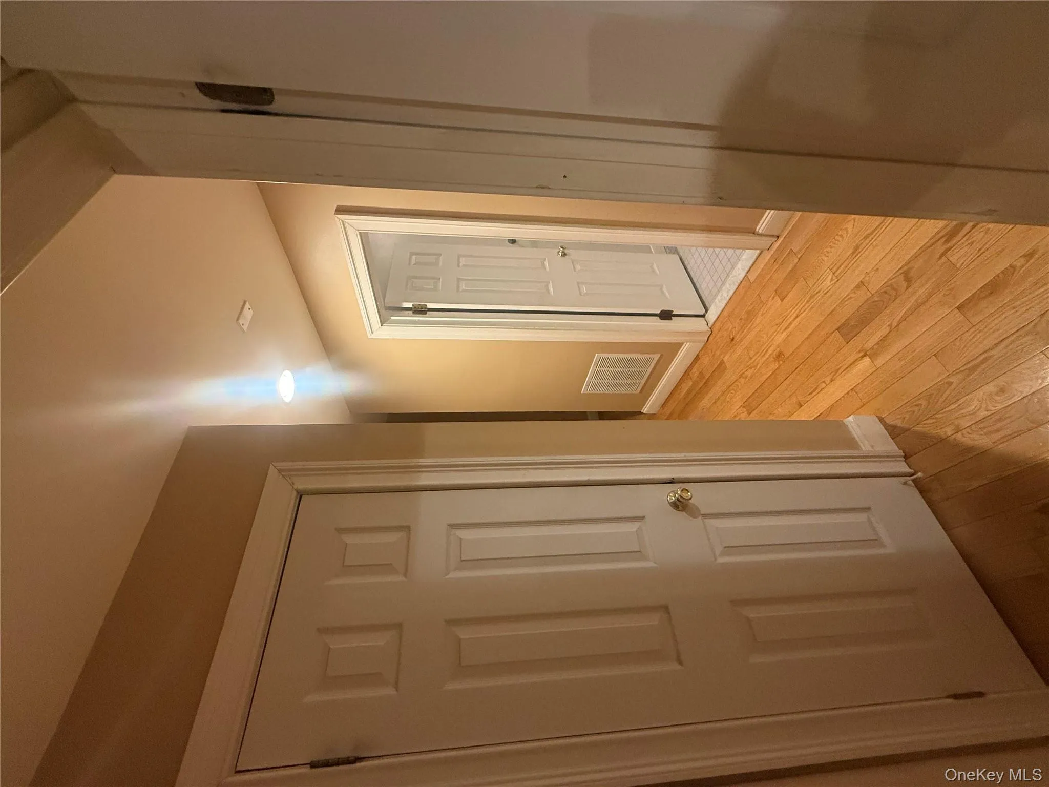 Bright hallway featuring classic six-panel doors, hardwood floors, and recessed lighting leading to the living areas. Bright hallway featuring classic six-panel doors, hardwood floors, and recessed lighting leading to the living areas.