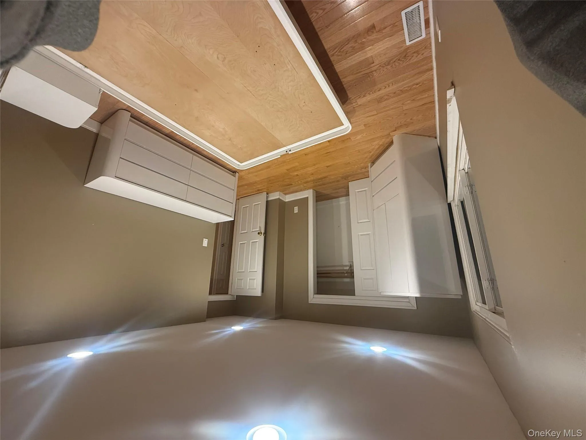 Spacious bedroom featuring hardwood flooring, recessed lighting, ample closet space, and warm neutral finishes. Spacious bedroom featuring hardwood flooring, recessed lighting, ample closet space, and warm neutral finishes.