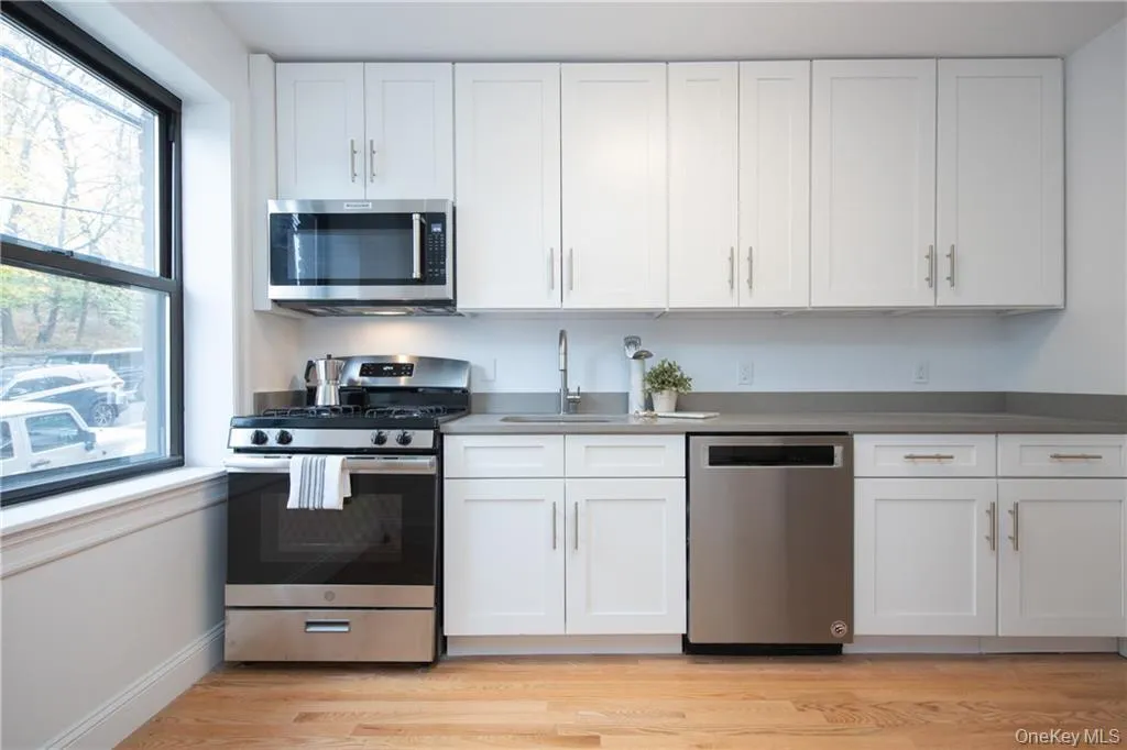 Kitchen featuring white cabinetry, sink, stainless steel appliances, and light wood-type flooring Kitchen featuring white cabinetry, sink, stainless steel appliances, and light wood-type flooring