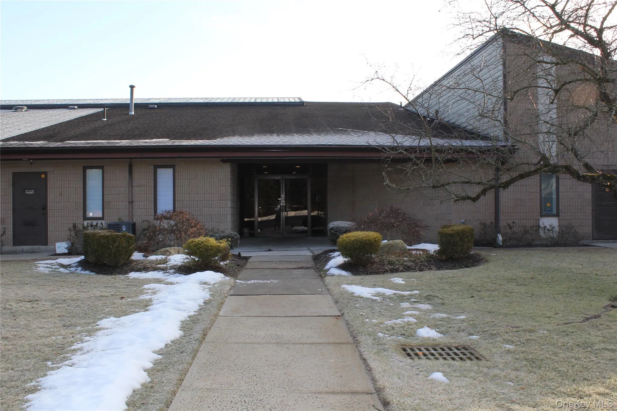 View of front of home with roof with shingles, concrete block siding, a front lawn, and french doors View of front of home with roof with shingles, concrete block siding, a front lawn, and french doors