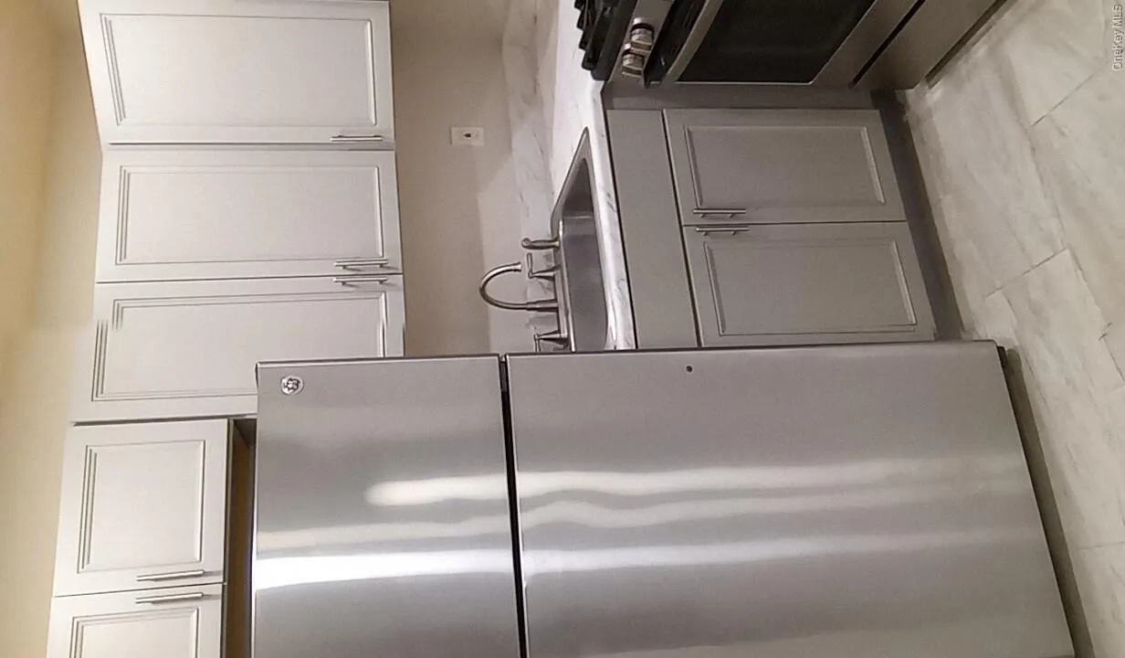 Kitchen featuring stainless steel appliances, gray cabinetry, and white cabinets Kitchen featuring stainless steel appliances, gray cabinetry, and white cabinets