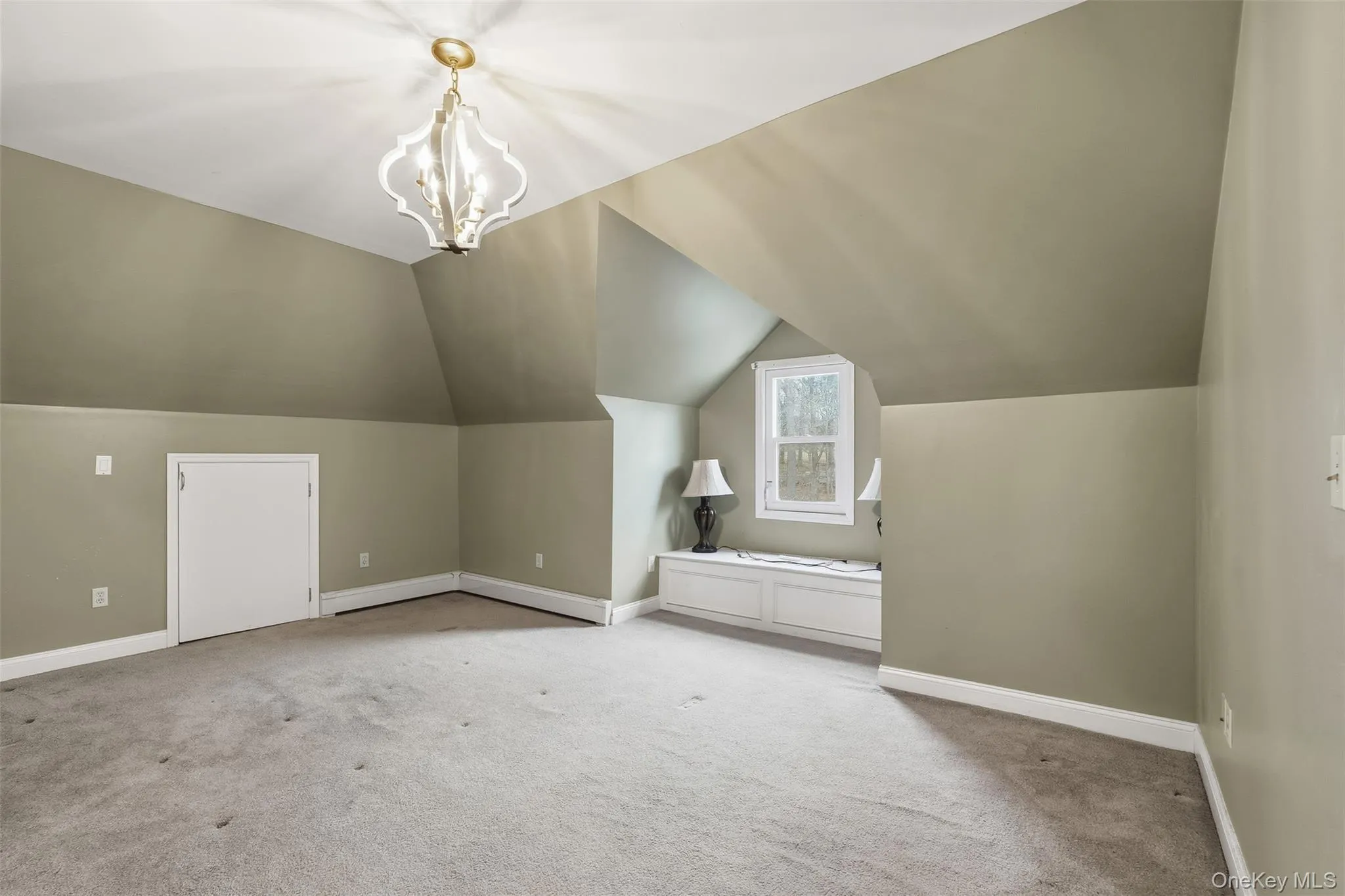 Additional living space featuring lofted ceiling, carpet floors, a chandelier, and a baseboard heating unit Additional living space featuring lofted ceiling, carpet floors, a chandelier, and a baseboard heating unit