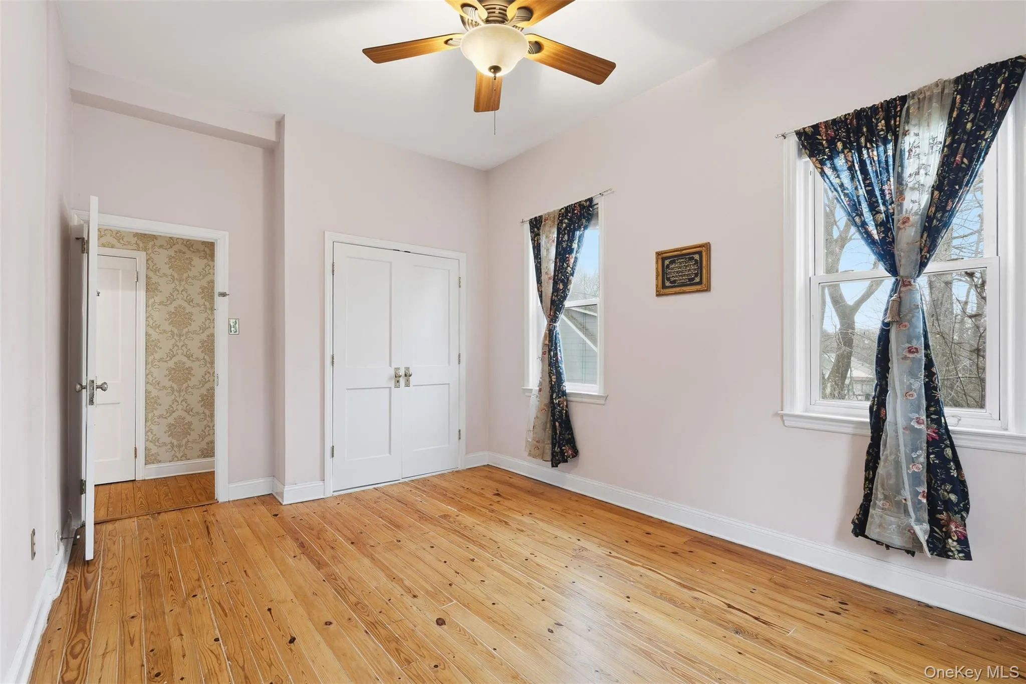 Unfurnished bedroom with light wood-type flooring, ceiling fan, and a closet Unfurnished bedroom with light wood-type flooring, ceiling fan, and a closet