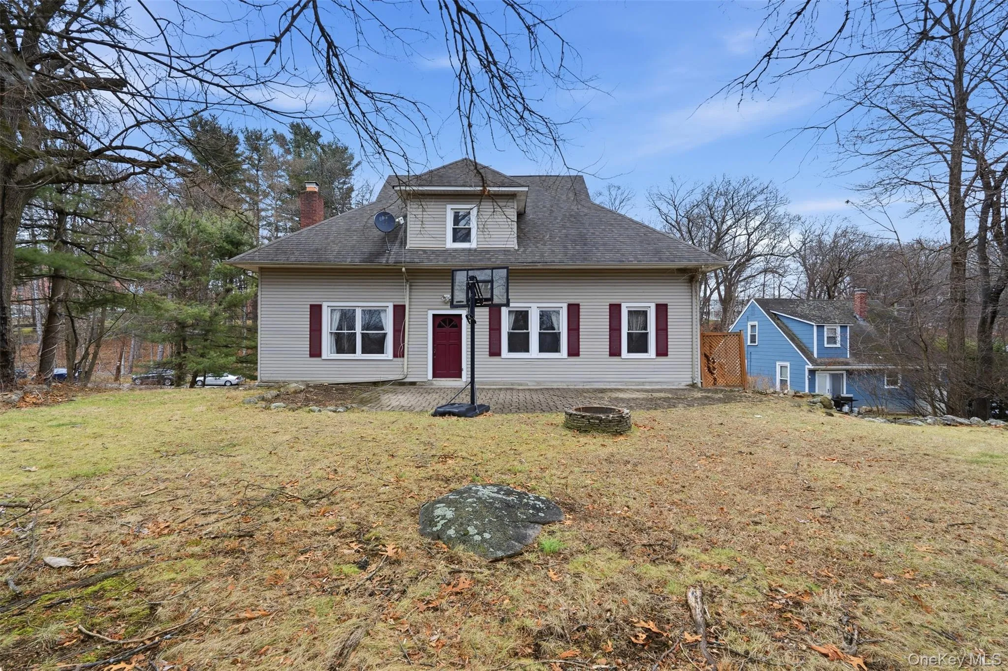 View of front of home featuring a front yard, a chimney, roof with shingles, and a fire pit View of front of home featuring a front yard, a chimney, roof with shingles, and a fire pit