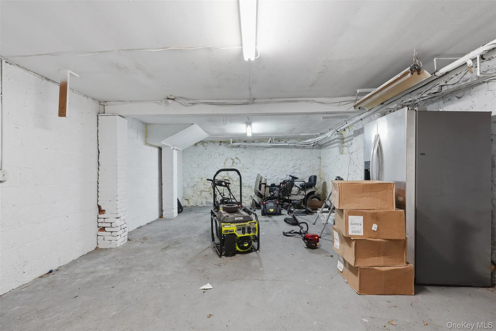 Unfinished basement with stainless steel fridge Unfinished basement with stainless steel fridge
