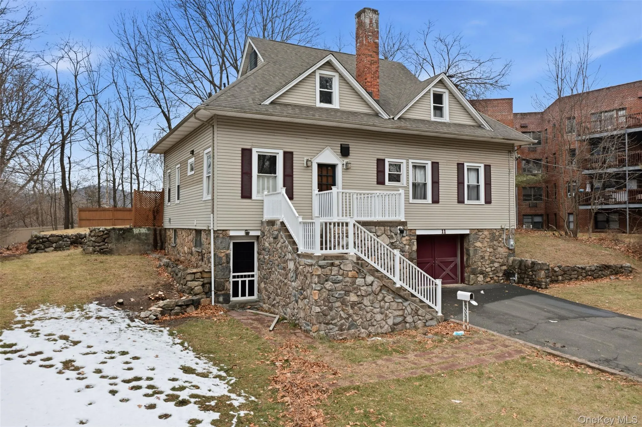 View of front of house featuring a chimney, roof with shingles, a front yard, stone siding, and stairs View of front of house featuring a chimney, roof with shingles, a front yard, stone siding, and stairs