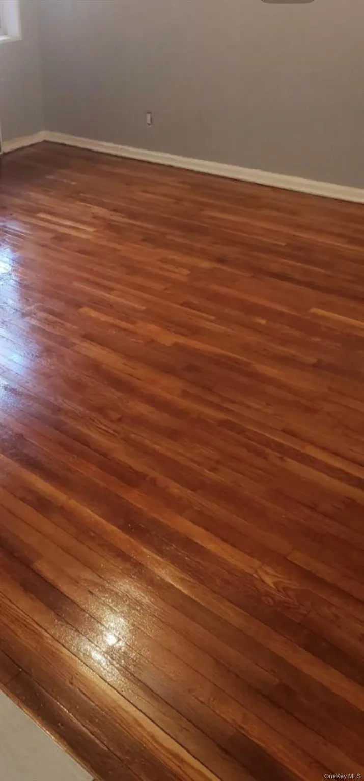 Spare room featuring dark wood finished floors and baseboards Spare room featuring dark wood finished floors and baseboards