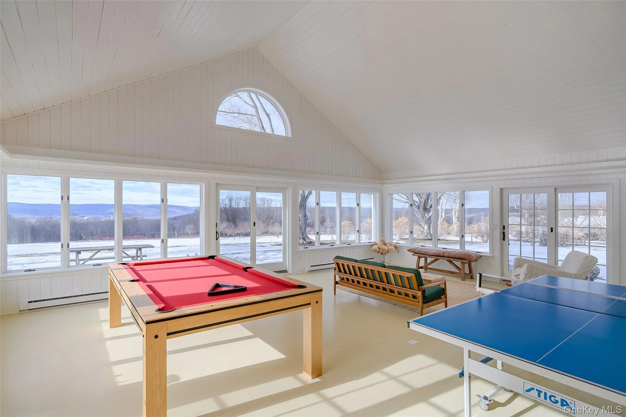 Rec room featuring billiards table, high vaulted ceiling, a baseboard radiator, and a mountain view Rec room featuring billiards table, high vaulted ceiling, a baseboard radiator, and a mountain view