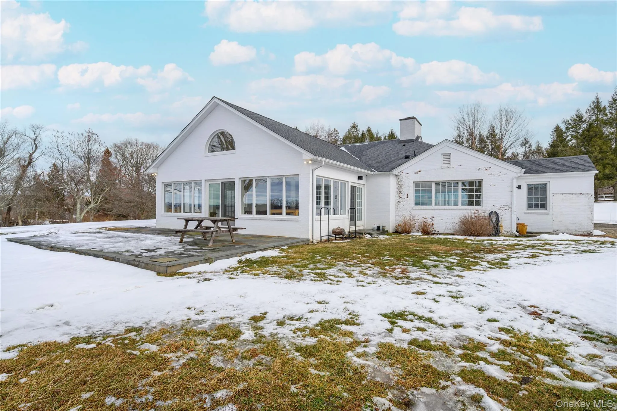 View of front of home featuring a chimney and a patio View of front of home featuring a chimney and a patio