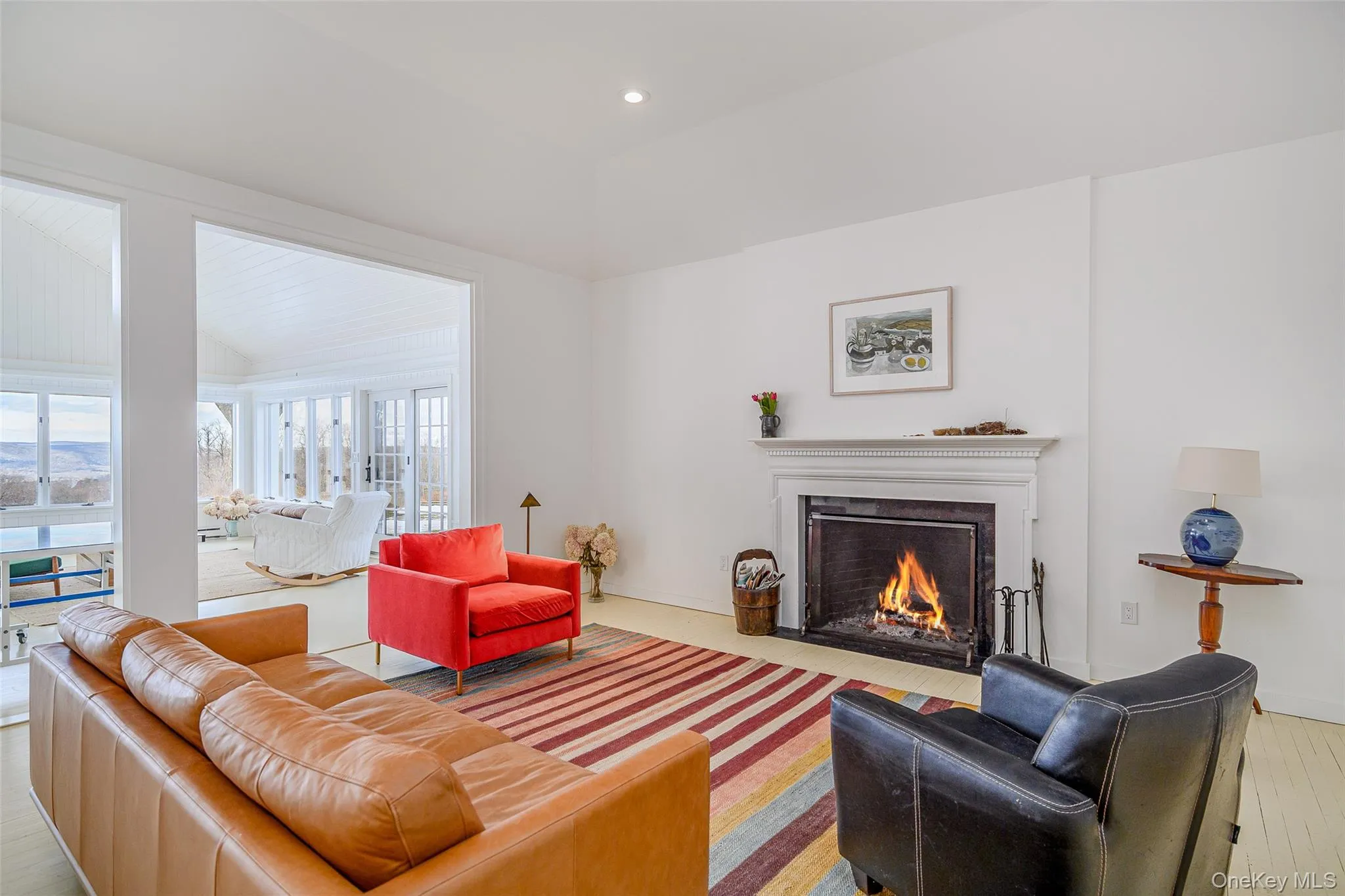 Living room featuring a fireplace with flush hearth, hardwood / wood-style floors, lofted ceiling, and recessed lighting Living room featuring a fireplace with flush hearth, hardwood / wood-style floors, lofted ceiling, and recessed lighting