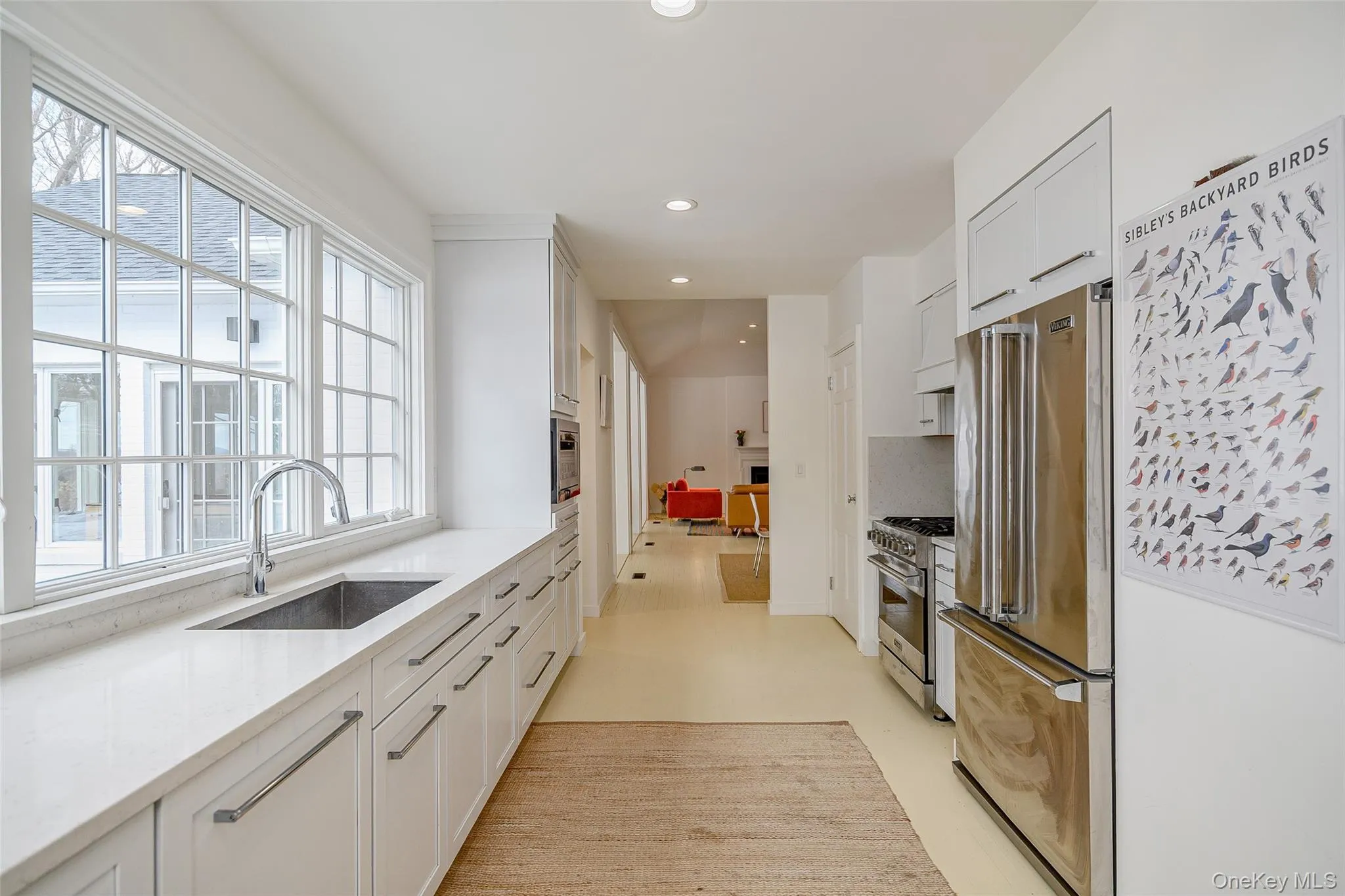 Kitchen featuring white cabinets, high end appliances, light stone countertops, and recessed lighting Kitchen featuring white cabinets, high end appliances, light stone countertops, and recessed lighting