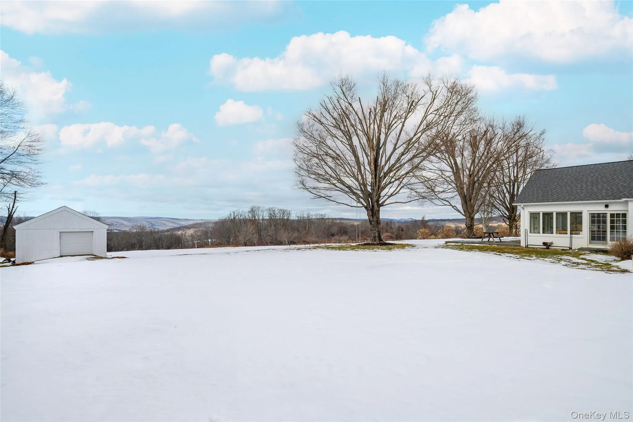 Snowy yard featuring an outbuilding and a sunroom Snowy yard featuring an outbuilding and a sunroom