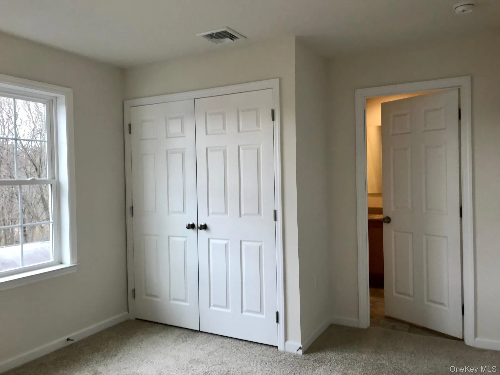 Unfurnished bedroom with carpet flooring and a closet Unfurnished bedroom with carpet flooring and a closet