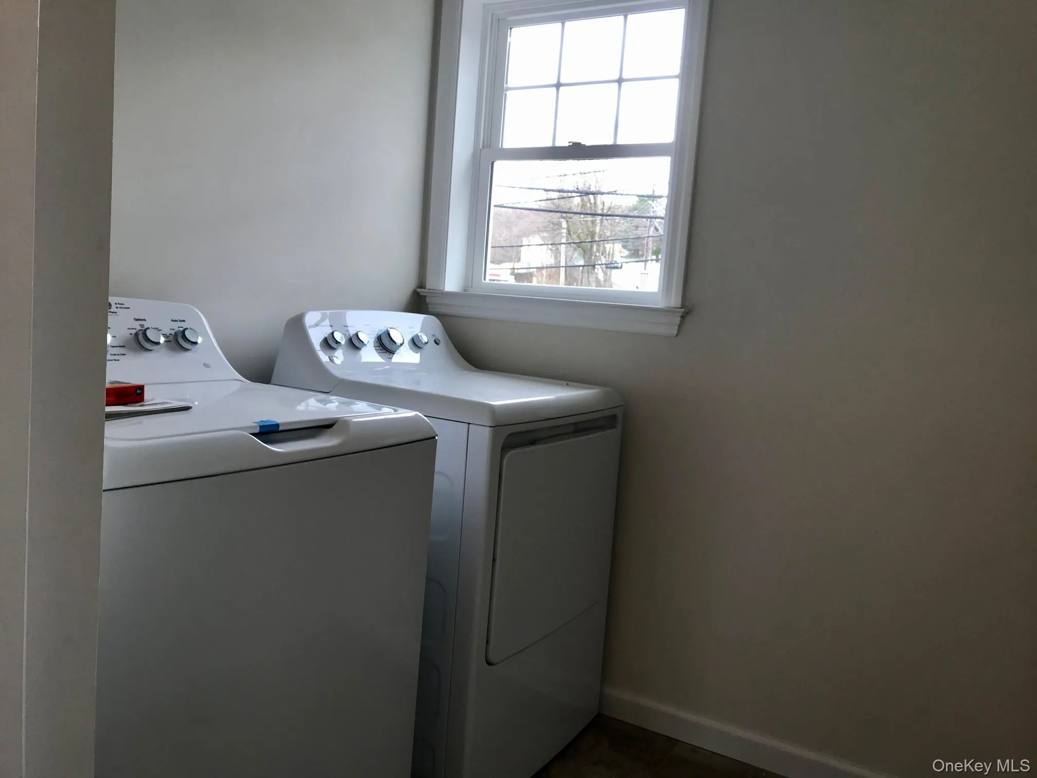 Laundry area featuring separate washer and dryer and baseboards Laundry area featuring separate washer and dryer and baseboards