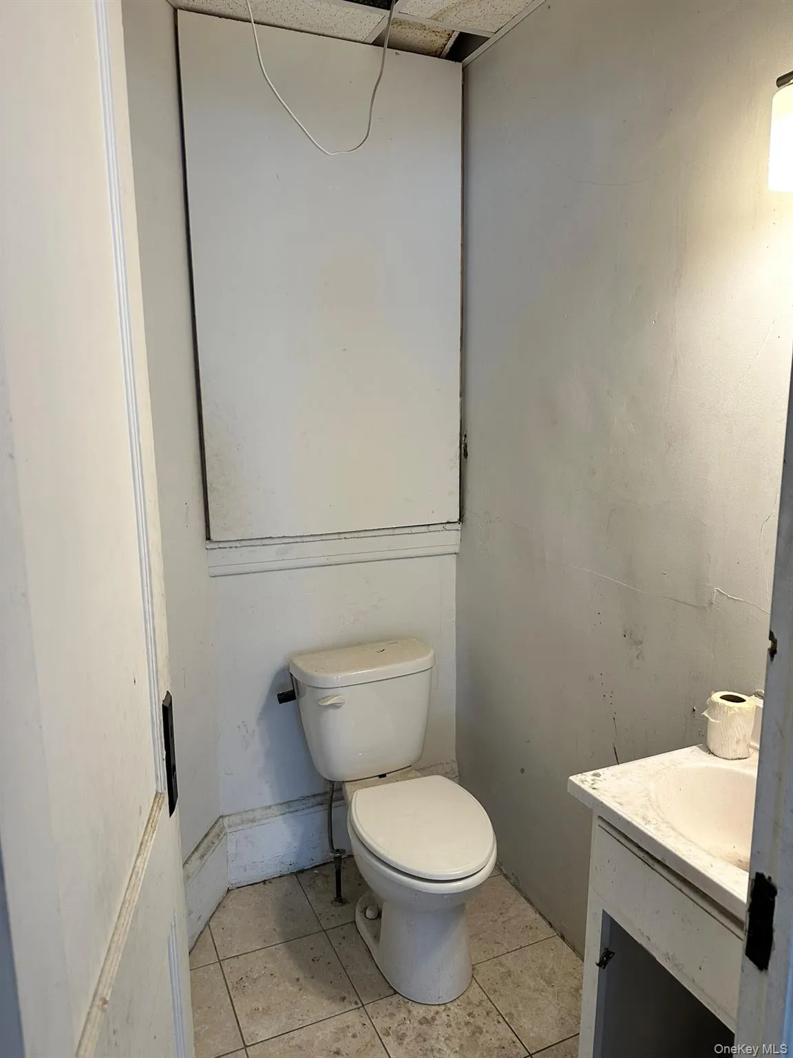 Half bathroom with light tile patterned floors and vanity Half bathroom with light tile patterned floors and vanity