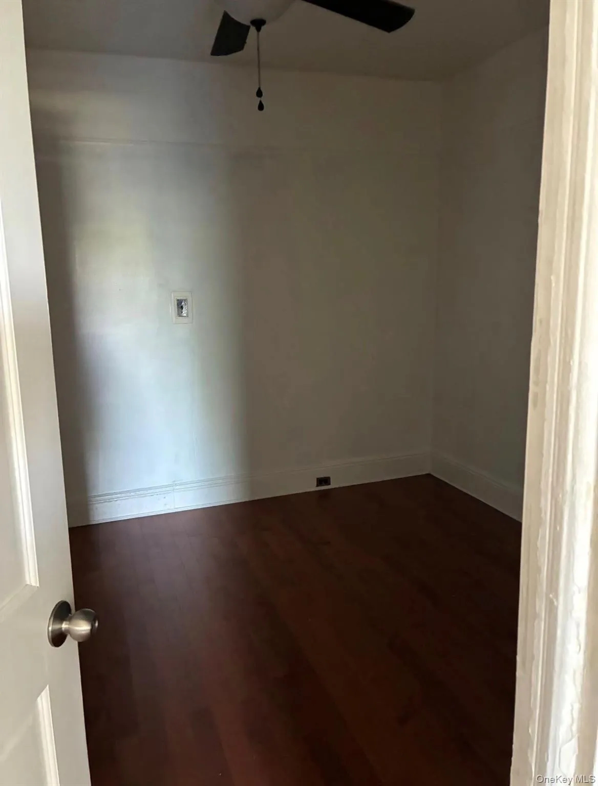 Spare room with dark wood-style flooring and a ceiling fan Spare room with dark wood-style flooring and a ceiling fan