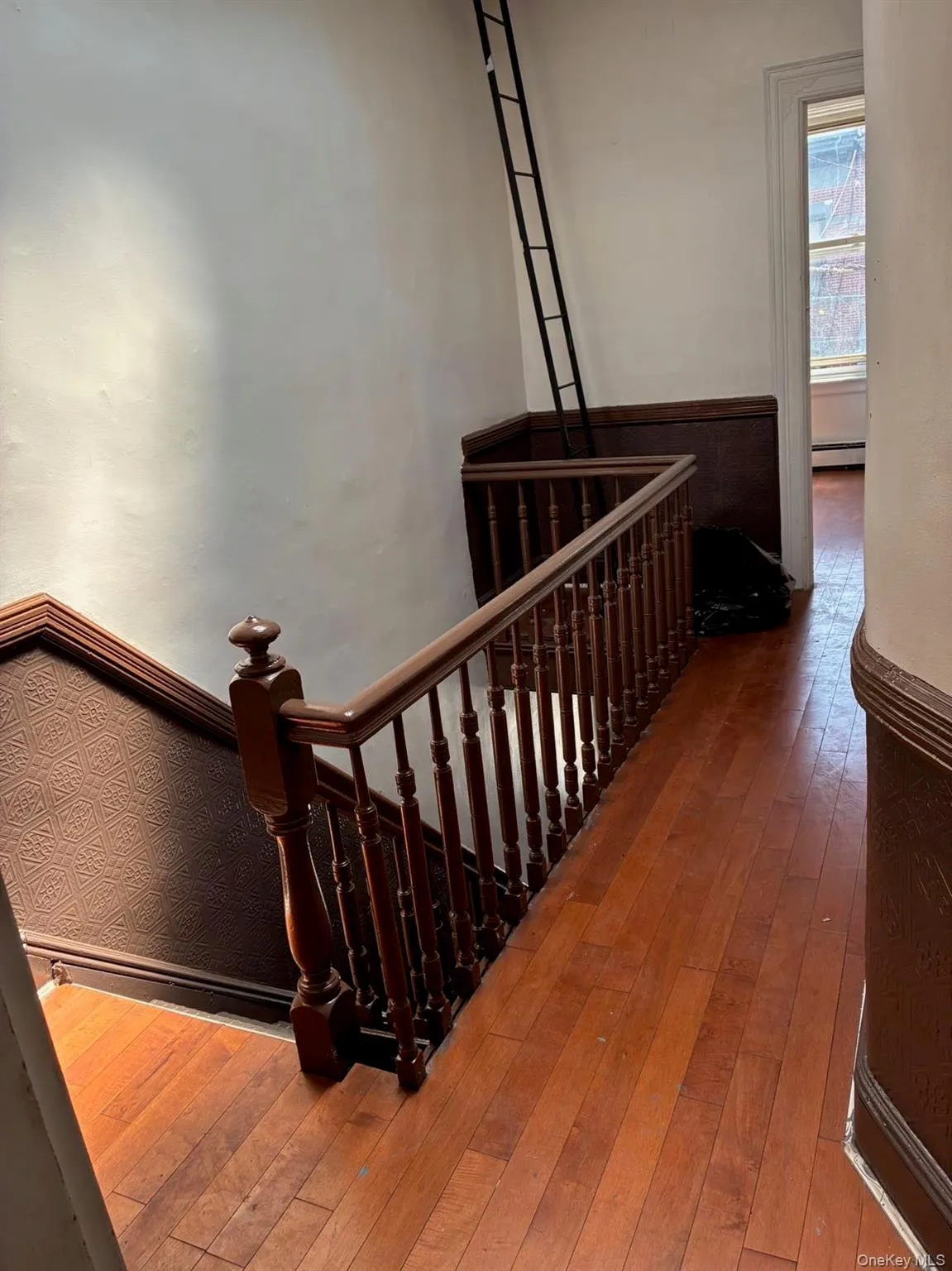 Staircase featuring hardwood / wood-style flooring and a baseboard heating unit Staircase featuring hardwood / wood-style flooring and a baseboard heating unit