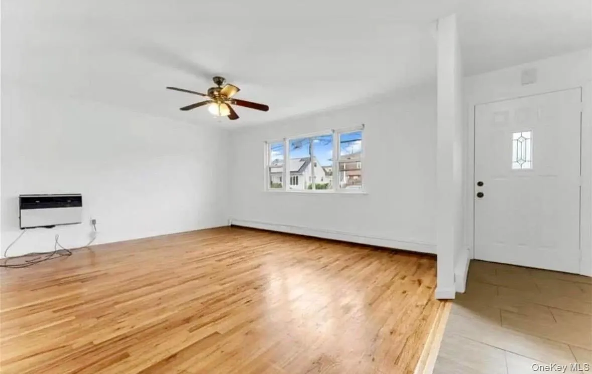 Entrance foyer featuring light wood-type flooring, a baseboard radiator, and ceiling fan Entrance foyer featuring light wood-type flooring, a baseboard radiator, and ceiling fan