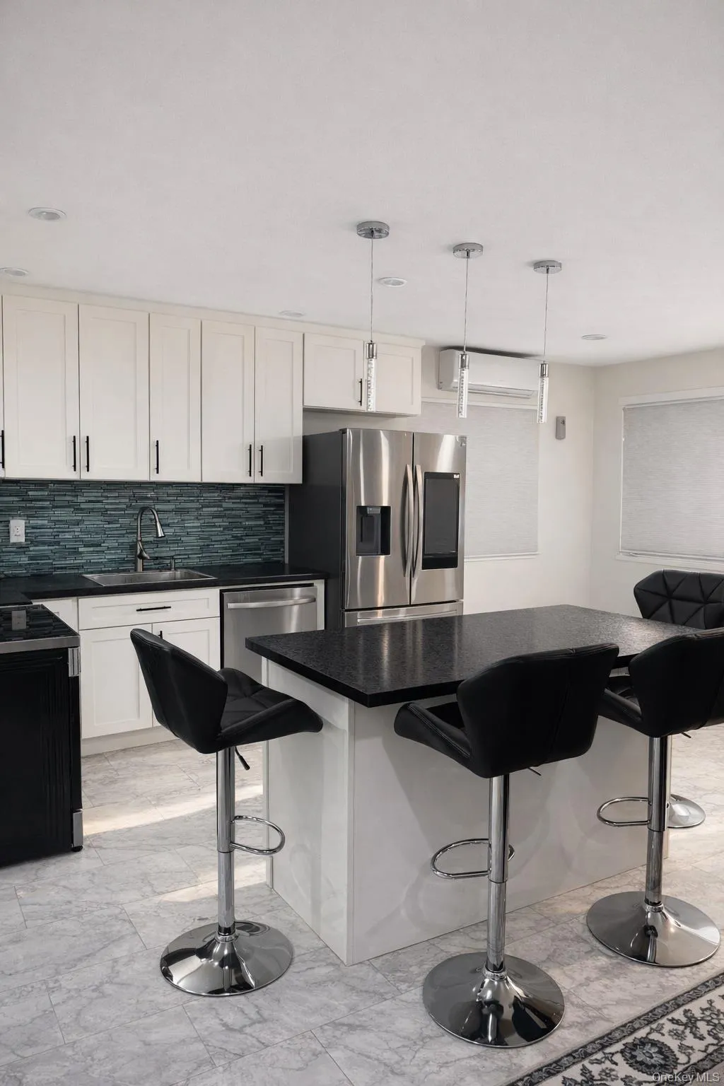 Kitchen with a kitchen bar, light marble finish flooring, pendant lighting, and tasteful backsplash Kitchen with a kitchen bar, light marble finish flooring, pendant lighting, and tasteful backsplash