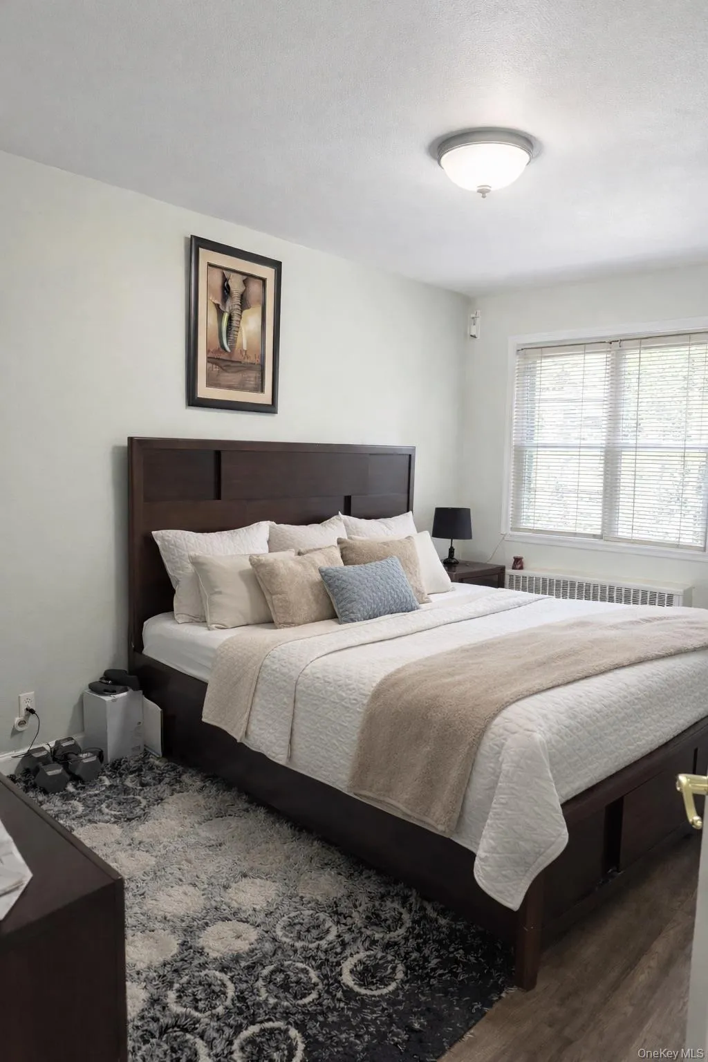 Bedroom with radiator heating unit and wood finished floors Bedroom with radiator heating unit and wood finished floors