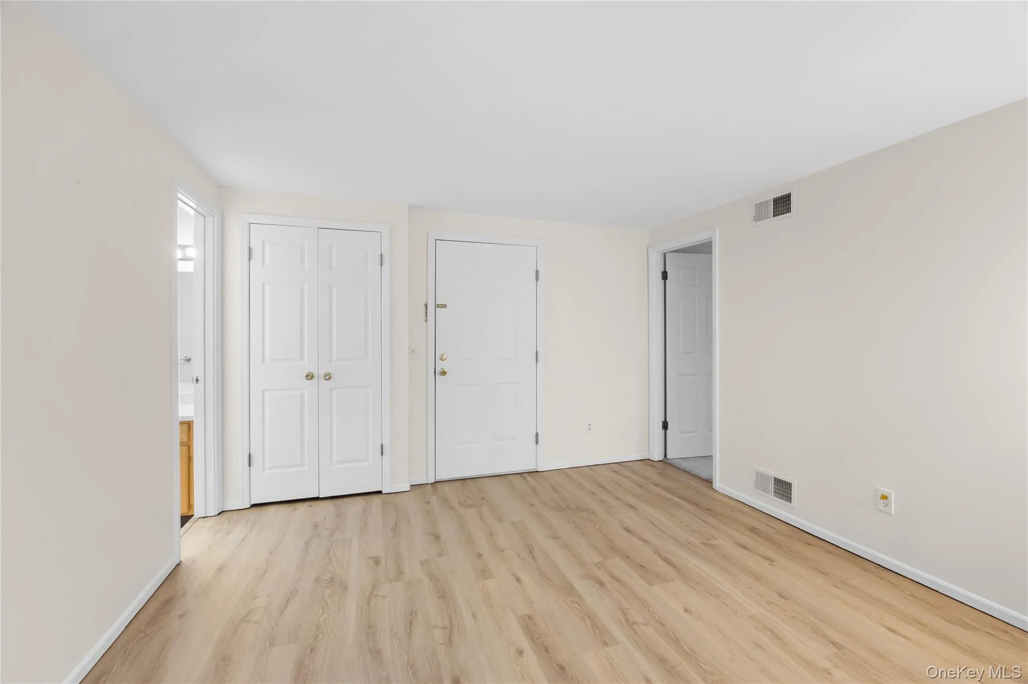 Unfurnished bedroom with a closet and light wood finished floors Unfurnished bedroom with a closet and light wood finished floors