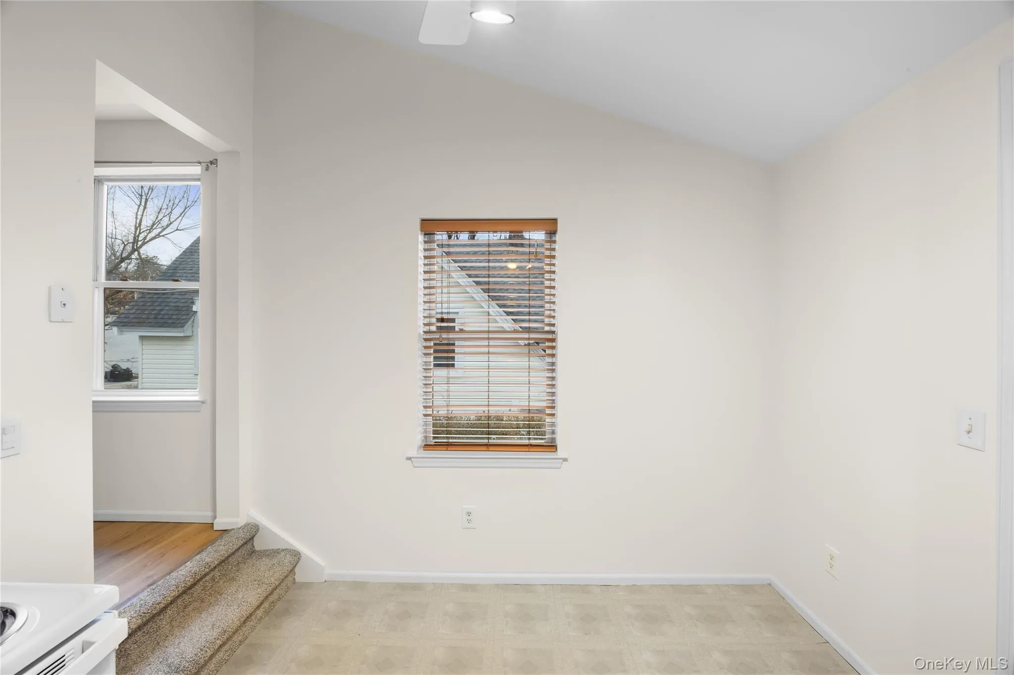 Empty room featuring lofted ceiling and light flooring Empty room featuring lofted ceiling and light flooring
