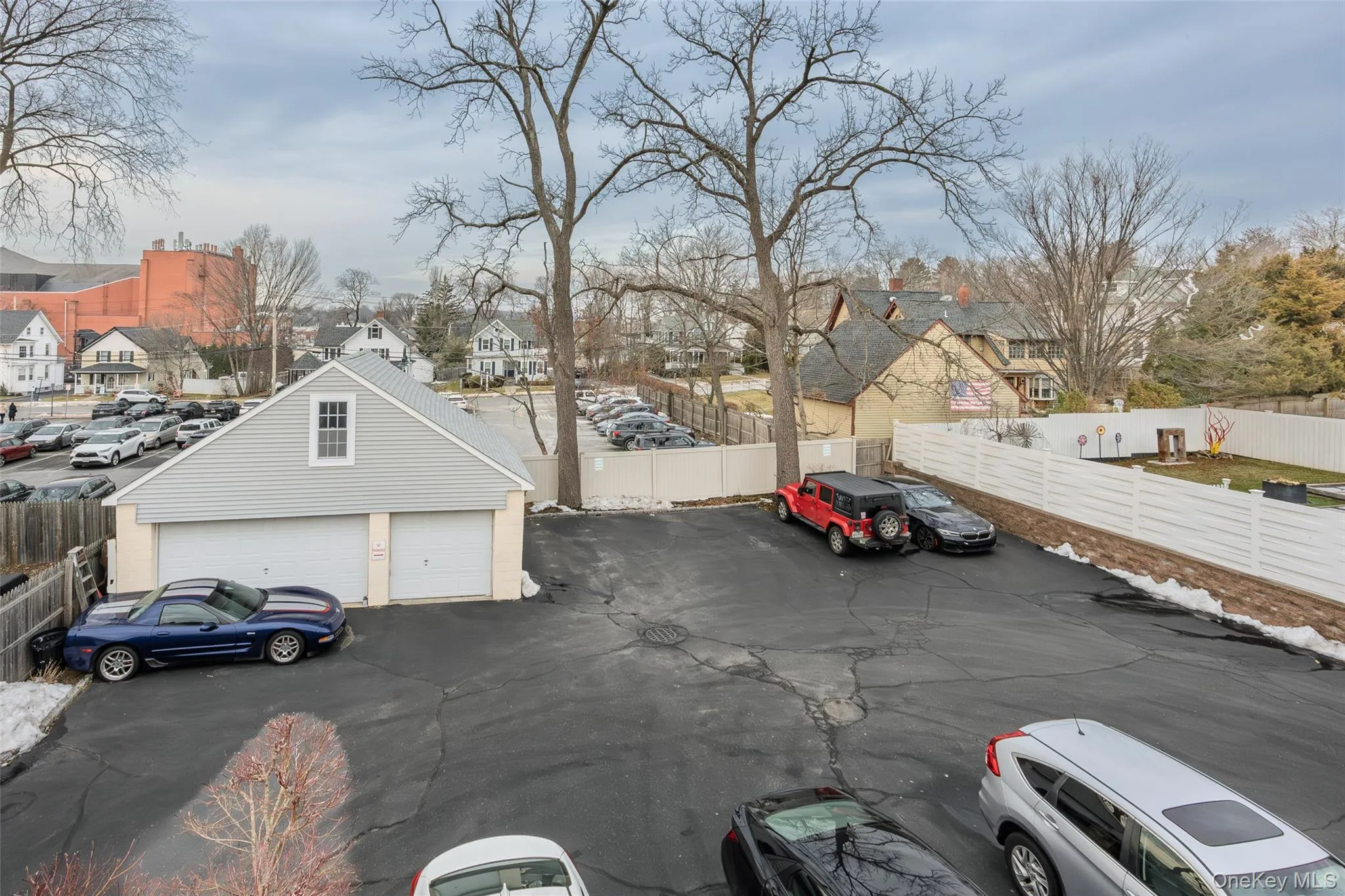 View of car parking featuring a residential view and a garage View of car parking featuring a residential view and a garage