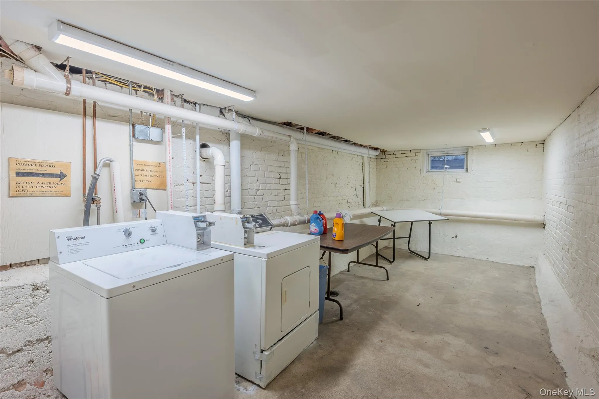 Laundry room with brick wall and washing machine and clothes dryer Laundry room with brick wall and washing machine and clothes dryer