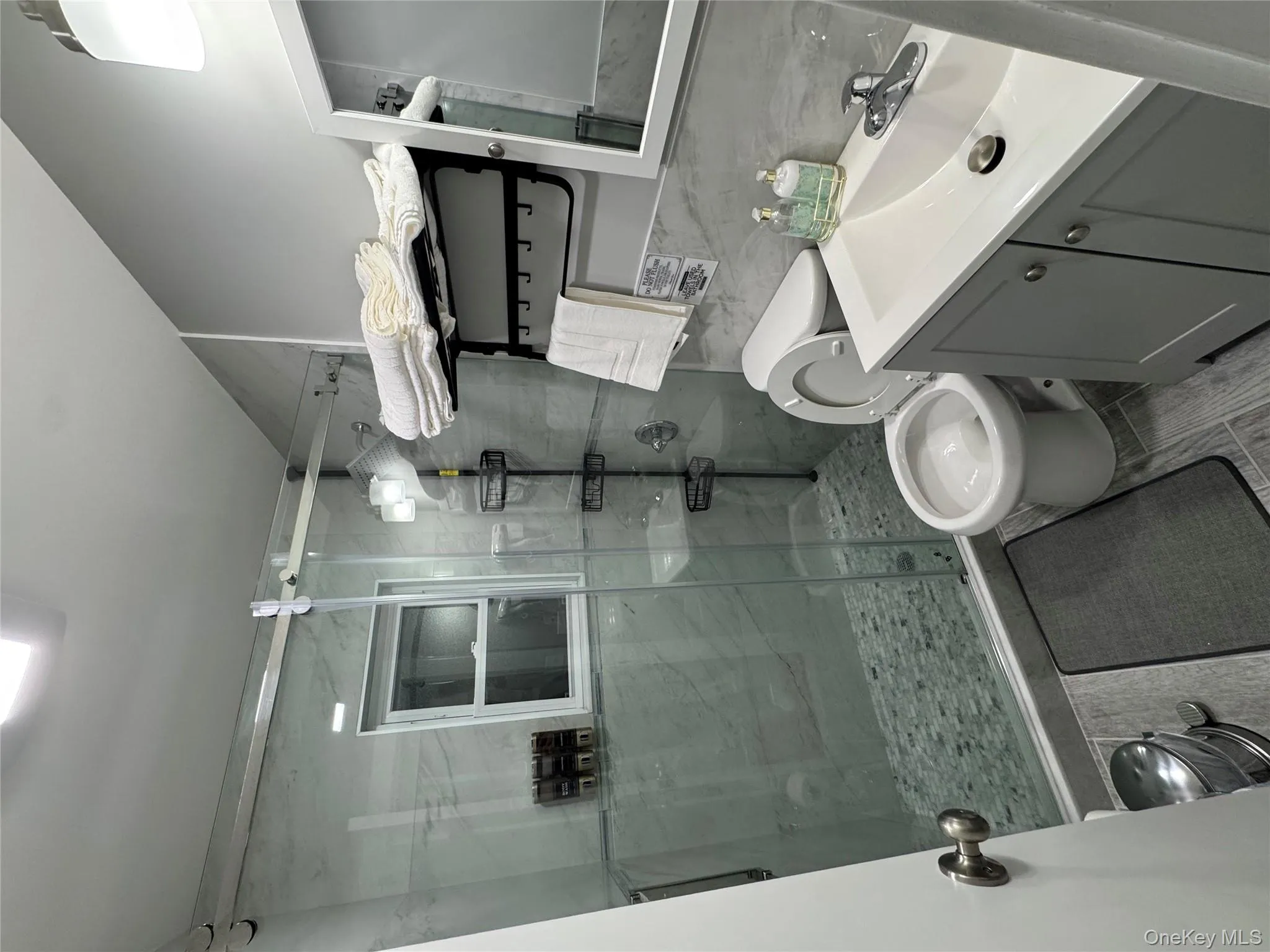 Bathroom with a shower stall, vanity, and tile walls Bathroom with a shower stall, vanity, and tile walls