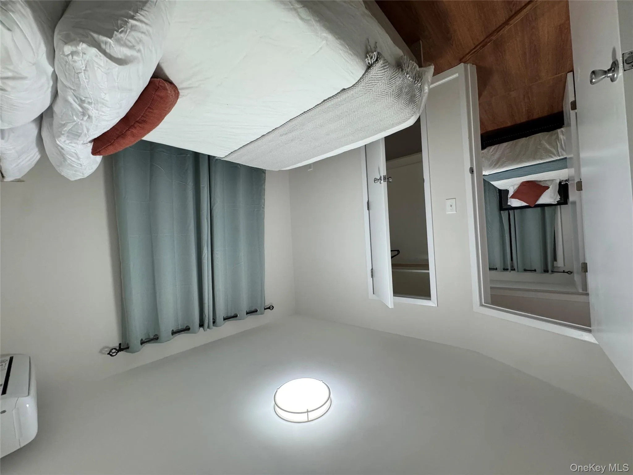 Bedroom with a wall mounted AC, wood finished floors, and a spacious closet Bedroom with a wall mounted AC, wood finished floors, and a spacious closet