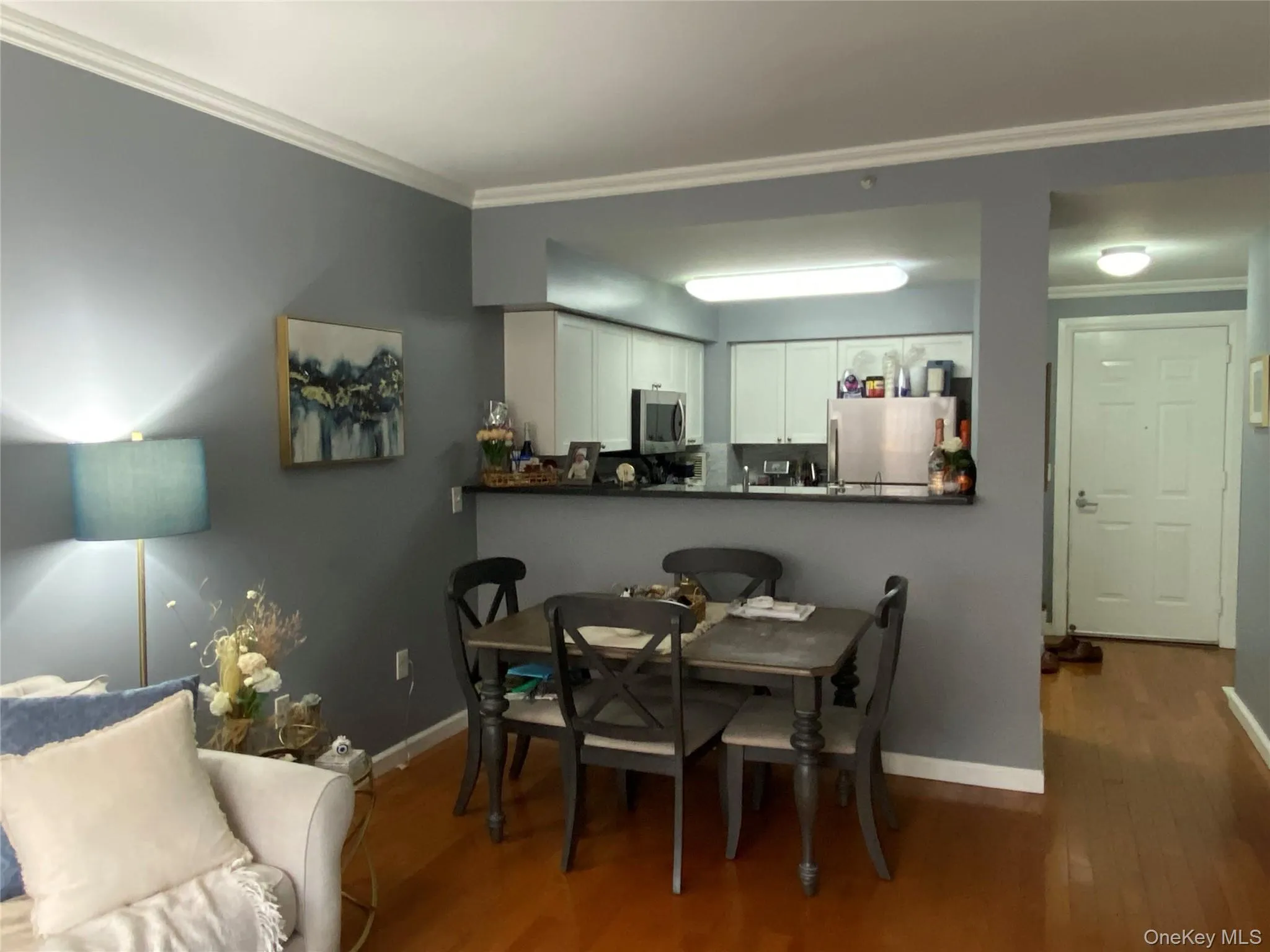 Dining area featuring crown molding and dark wood-style flooring Dining area featuring crown molding and dark wood-style flooring